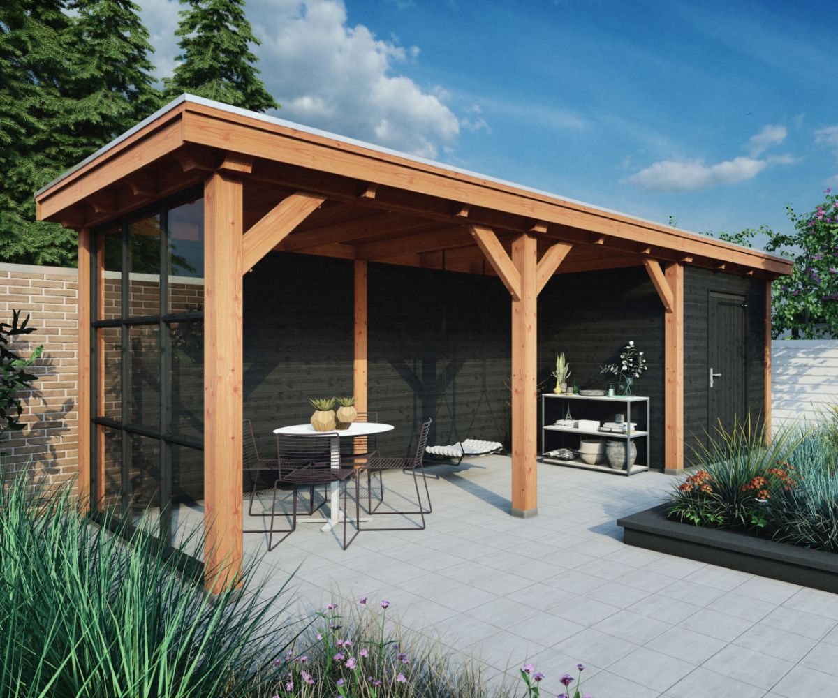 Een moderne houten pergola met een gedeeltelijk glazen wand, met daarboven een zitgedeelte met een ronde tafel en twee stoelen op een betegeld terras, omgeven door planten en bomen.