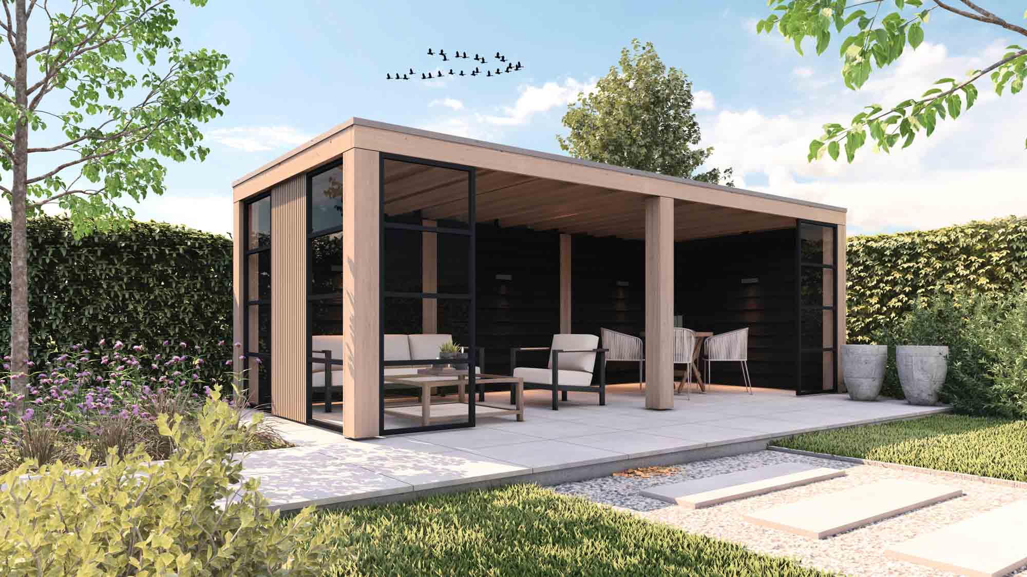 Een moderne houten tuinprieel met glazen wanden staat op een betegeld terras, ingericht met stoelen, een tafel en potplanten. Groene bomen en heggen omringen het terrein onder een blauwe lucht met vogels die erboven vliegen.