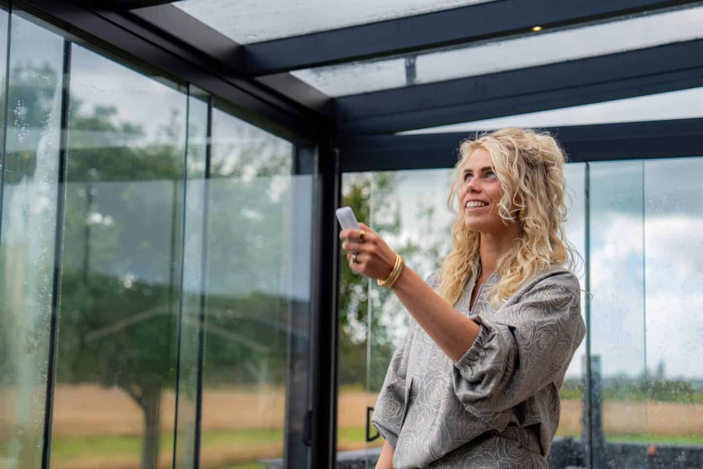 Lamella outdoor dak met heldere glassafel en zwart frame.